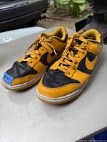 Pair of yellow and black Nike running shoes from side angle showing design and condition.