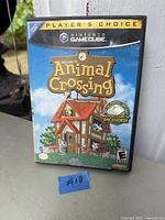 Photo of Nintendo GameCube game 'Welcome to Animal Crossing', showing front cover with Player's Choice label and included memory card sticker.
