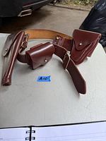 Leather RCMP belt holster with pouches displayed on a white surface