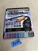 Rectangular metal tin box with image of toucan, containing 18 coloured pencils in various shades, labeled with color codes