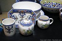 Various handpainted dinnerware pieces including Tiffany porcelain salad bowl, creamer, sugar set, and Portuguese blue and yellow bowls and plates