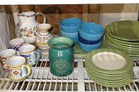 General overview of the collection showing pitchers, mugs, bowls, and plates arranged on a shelf.