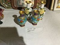 Overall view of 4 cloisonné vases, two medium white and two smaller blue, on a white surface