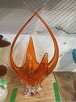 Full view of the orange Chalet style art glass vase showing its height and pointed upward extensions.