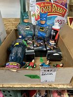 Two large Batman coin banks and various small figurines in a box.