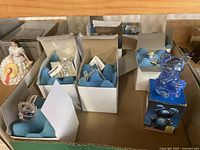 View of various miniature crystal animal figurines and the blue crystal bear in box