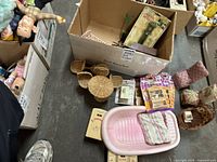Overview of lot showing pink plastic baby doll bathtub with cloth towel, some wicker furniture components, wooden accessories, and original packaged doll accessories in a box
