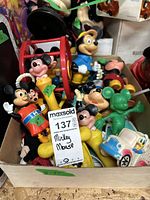 Box of assorted Mickey Mouse figures and toys showing various colors and wear.