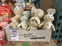 Group of Pillsbury Dough People figures, white with blue eyes, boxed together with visible wear and scuffs.