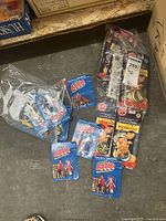 Multiple miniature Annie figures in original blue blister card packaging and several sets of Disney Pocahontas Pogs in original clear blister packaging on black cards.