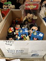 Box with multiple vintage Mickey Mouse and Disney character toys and collectibles including pencil sharpeners and figurines.