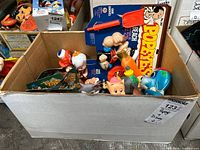 Box full of assorted vintage miniature toys, showing multiple figures and packages visible inside the box.