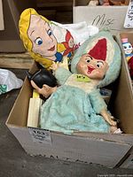 Box containing the 20" plush figure, Alice in Wonderland plush pillow, Batman figure head, and other toys.