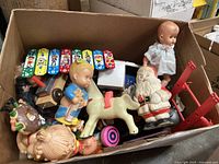 Box containing assorted vintage toys including baby doll, Santa figure, rocking horse and golf player figure