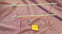 Front view of pink metal ballet barre with two cream bars