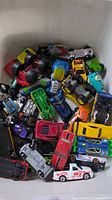 Heap of assorted toy cars in bin