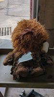 Full view of Chewbacca plush seated on surface