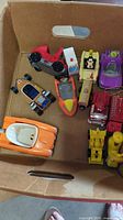 Overview of assorted die-cast cars inside cardboard box