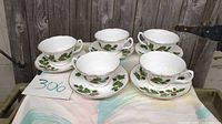 Five teacup and saucer sets displayed