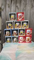 Front view of 15 boxed Norman Rockwell mugs stacked.