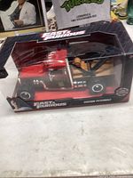 Front view of Fast & Furious Custom Peterbilt die-cast model in original packaging, showing red and black truck with chrome details.