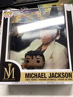 Michael Jackson Funko Pop vinyl figure in original box showing the front with artwork of Michael Jackson in white suit and figure in front. The box is visibly damaged with wear on edges.