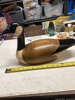 Side view of the Jim Harkness 1983 wooden goose decoy showing the natural wood grain on the wings and detailed painting on the head and neck.