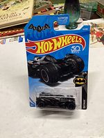 Photo of unopened Hot Wheels Batman Arkham Knight Batmobile die-cast car in original blister pack with 50th anniversary Hot Wheels logo and Batman branding.