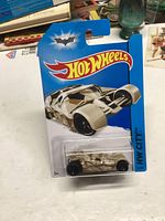 Hot Wheels Tumbler Batmobile 2013 camo die-cast car in unopened original packaging on blue Hot Wheels card with Batman logo