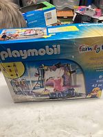 Front view of Playmobil Family Fun box showing title, image of the singer figure on stage with microphone and backdrop, number of pieces and age range.