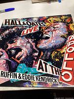 Front cover of Hall and Oates Live at the Apollo vinyl showing bright illustrated design with performers' faces and text