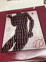 Front cover of the vinyl record sleeve showing abstract silhouette art with maroon border.
