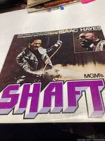 Front cover of the Shaft soundtrack vinyl record by Isaac Hayes showing bold text and images from the movie