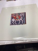 Front cover of Paul Simon Graceland vinyl album showing artwork and text on a cream-colored sleeve.