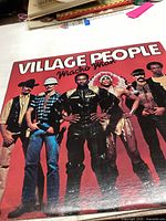 Front cover of Village People Macho Man album with band members in costume against red background.