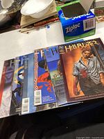 Six Hellblazer comic books laid out on a table with other household items visible in background