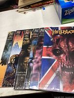 Photo showing six Hellblazer comic books fanned out, with visible cover art featuring dark, supernatural imagery.