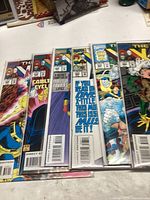 Six X-Men comic books laid out in a row, showing the front covers with various characters.