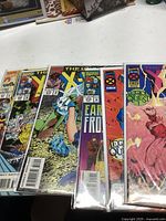Six Marvel X-Men comic books in plastic sleeves on white surface, showing front covers with vibrant comic art and Marvel branding.