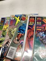 Six Uncanny X-Men comic books stacked showing partial front covers with identifiable issue numbers and Marvel Comics logo.