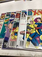 Stack of six X-Men comic books in protective sleeves showing colorful covers.