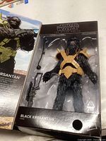Photo of unopened Star Wars The Black Series Black Krrsantan action figure showing front with visible armor and accessories in packaging.