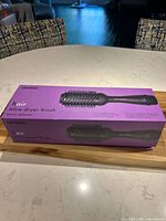 AMIKA hair blow dryer brush in its original purple box on a kitchen counter