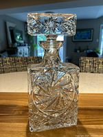 Front view of square lead crystal decanter with detailed hand cut pinwheel pattern on the body and square stopper.