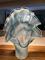 View looking inside the ruffled top of the vase showing the turquoise and white swirl pattern and clear edge