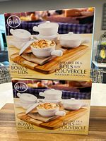 Two boxed sets each containing 6 white ceramic onion soup bowls with lids from BIA, new in box.