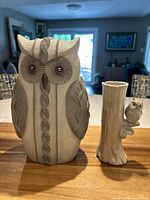 Resin owl figurine with cable knit design and porcelain owl bud vase together on wood surface