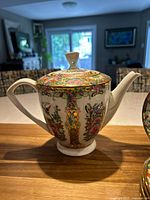 Teapot with lid and handle showing ornate floral and gold detail