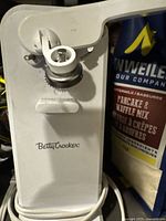 White Betty Crocker electric can opener showing front brand logo and cutting mechanism with some wear.