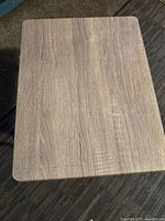 Top view of rectangular medium folding table showing wood grain laminated surface with minor scratches.
